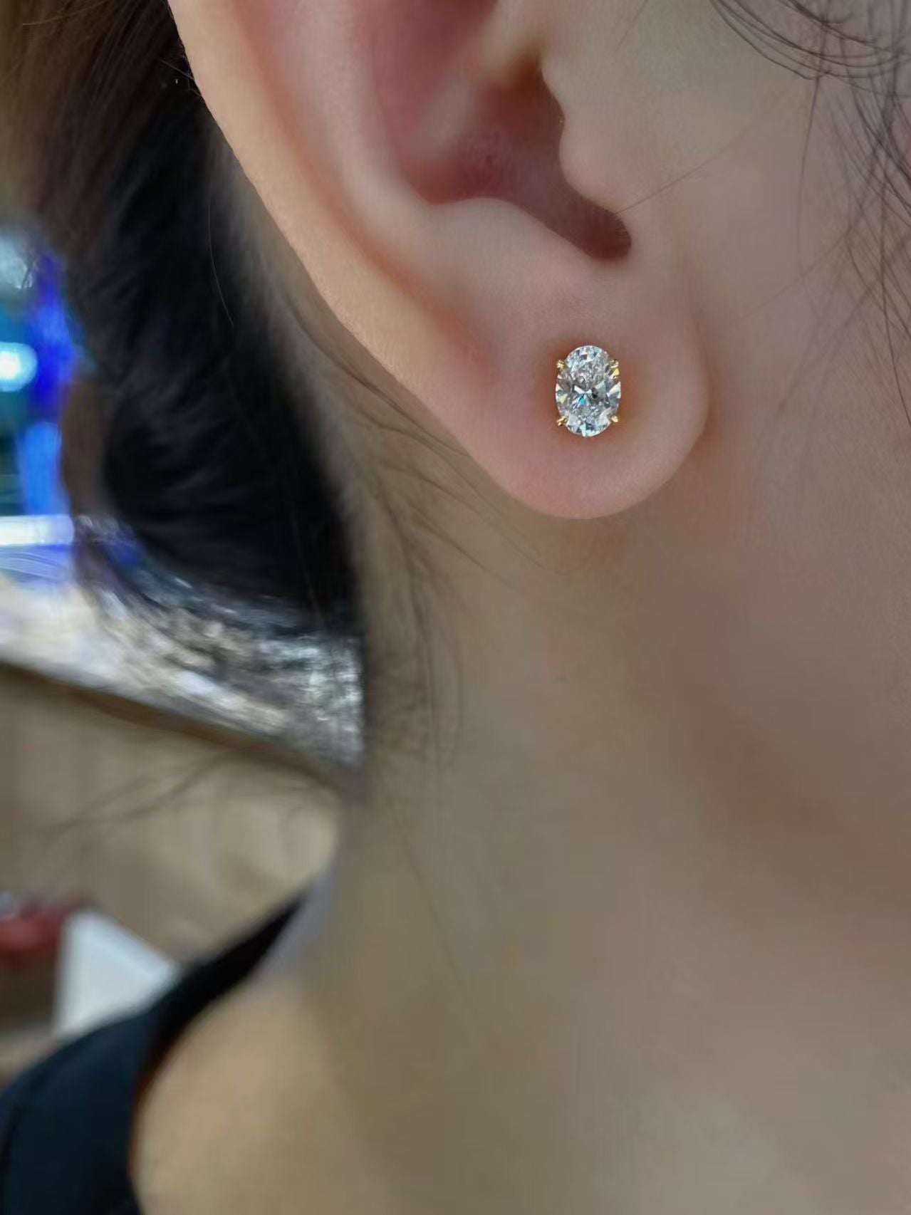 Oval solitaire lab diamond stud earrings worn on ear